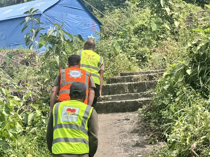 Volunteers climb the steps to the site of the tents