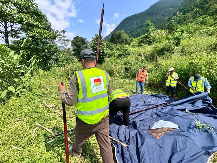 Unfolding a tent on the hillside