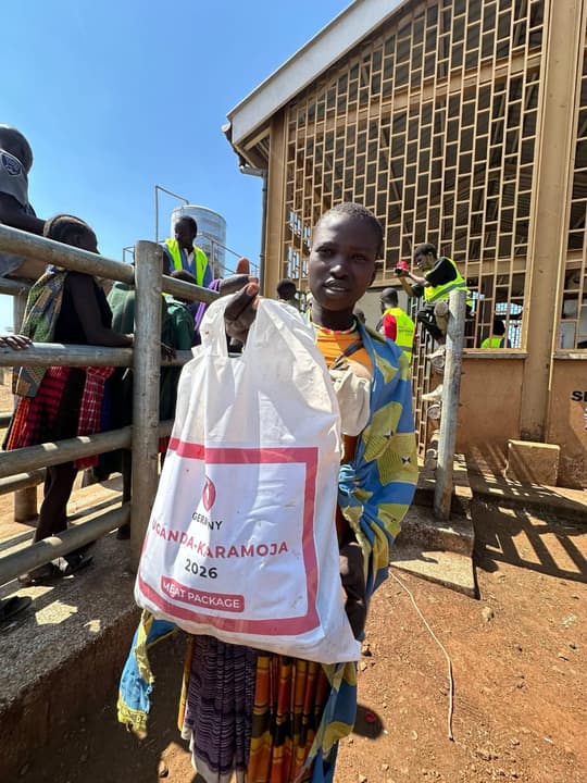 A young woman shows the “Uganda – Karamoja 2026” aid bag she has just received