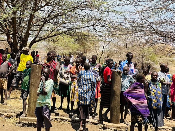 Families waiting for the distribution in the shade of the trees