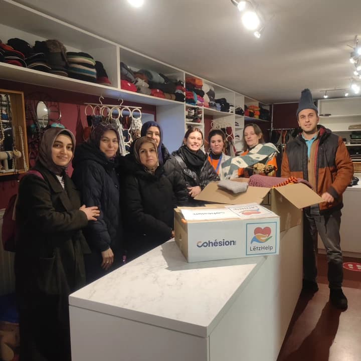 Handing over the boxes of hats and gloves to Stëmm vun der Strooss