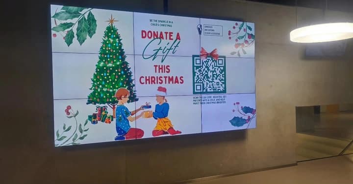 The campaign announcement on a video wall: “Donate a Gift this Christmas”